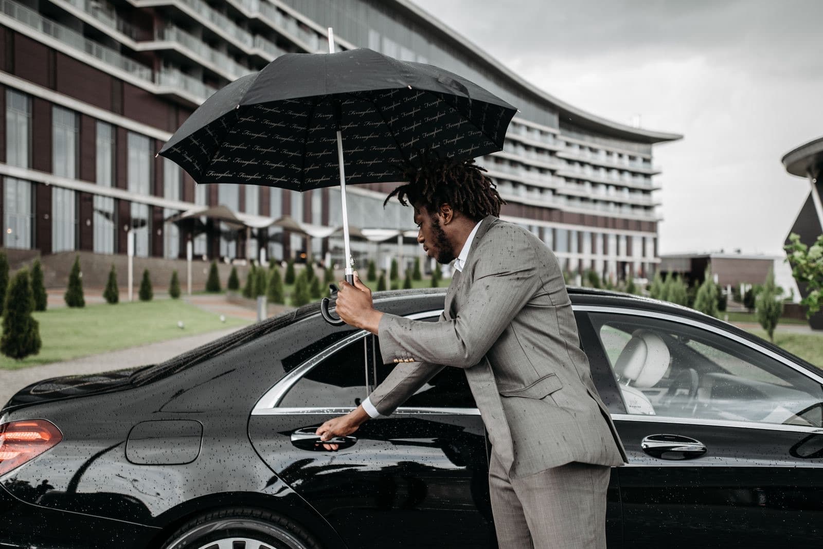 Chauffeur opening the rear door of a luxury saloon